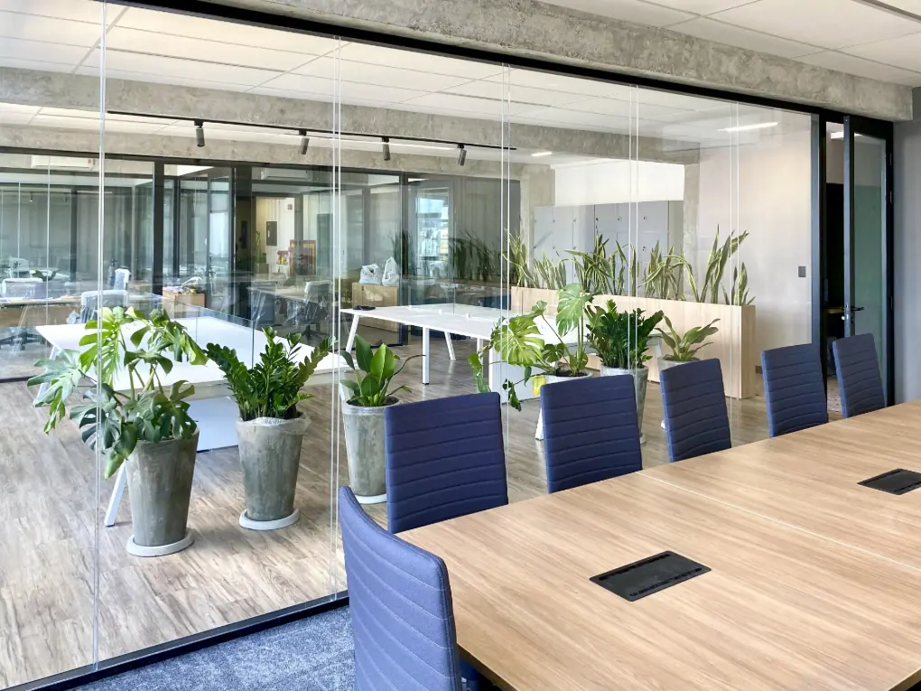 Sala de reunião com divisórias de vidro e acabamento corporativo